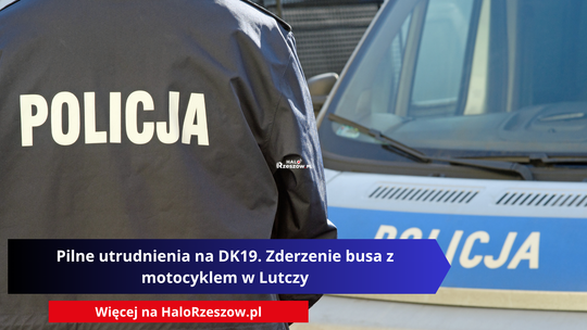 Zdjęcie przedstawia funkcjonariusza policji od tyłu, ubranego w granatową kurtkę służbową z widocznym na plecach dużym, białym napisem „POLICJA”. W tle widać fragment przodu radiowozu policyjnego.