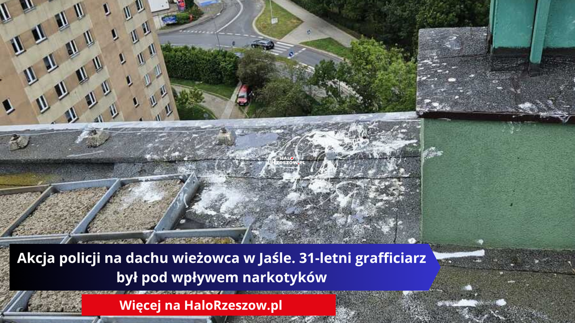 Akcja policji na dachu wieżowca w Jaśle. 31-letni grafficiarz był pod wpływem narkotyków Widok z dachu wysokiego bloku na ulicę i budynki. Na pierwszym planie widać zanieczyszczenia z farby na dachu.