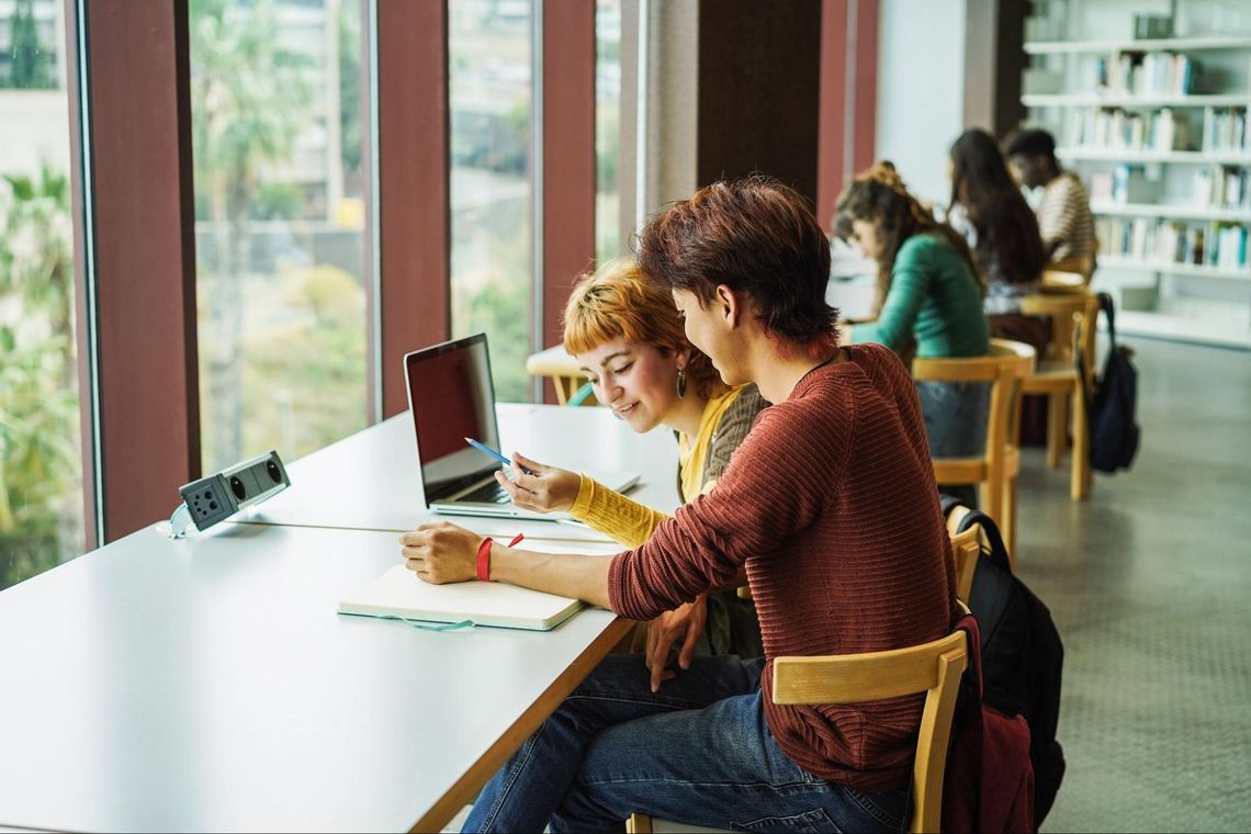 studenci przy biurku w bibliotece